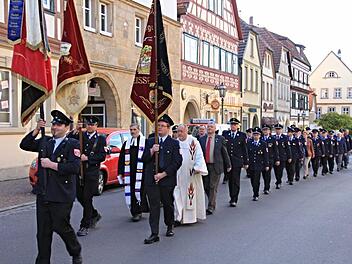 Von der Kirche zum Rathaus zogen die Feuerwehrleute mit Fahnenabordnungen, der Geistlichkeit und den Offiziellen. Foto: Helmut Will