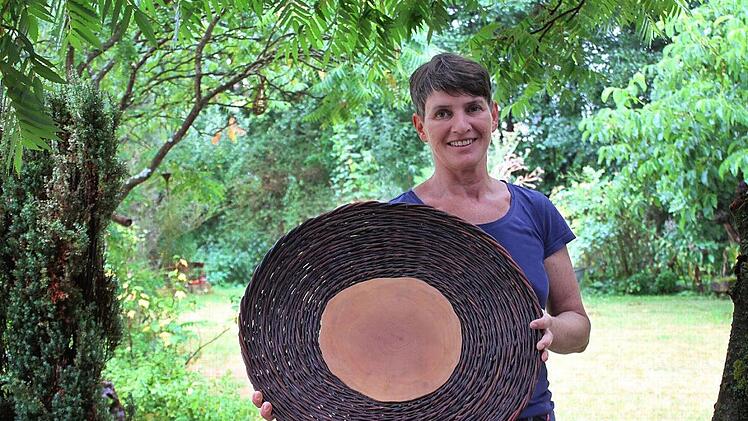 Brigitte Klitzner und die geflochtene Schale mit Baumscheiben-Boden in ihrem Garten in Ebensfeld Foto: Popp