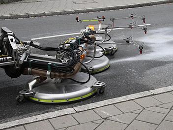 Der futuristisch aussehende Arbeitsarm des Ölspurbeseitigungslastwagens löst mit Wasser unter Hochdruck die Verunreinigung und saugt in diesem Falle den Diesel auch gleich auf. Fotos: Michael Busch