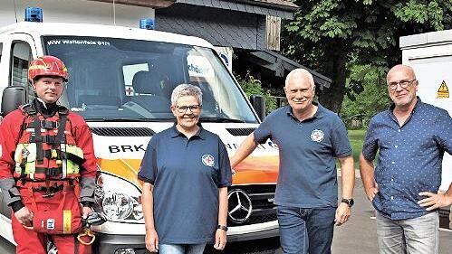 Technischer Leiter Jürgen Fabritzek (links) ist in den neuen Trockenwassserretteranzug geschlüpft. Vorsitzender Armin Bandorf (Zweiter von rechts) und Kassiererin Christa Förner dankten dafür dem Spender Klaus Wilhelm.