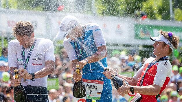 Als ehemaliger Radprofi ist der Australier Cameron Wurf ge&uuml;bter im Champagner-Flaschen-&Ouml;ffnen als Andreas Dreitz (Mitte) und Jesper Svensson. So bekamen der 30-j&auml;hrige Michelauer bei seinem Triathlontriumph in Roth und der zweitplatzierte Schwede  die volle Breitseite der Weinbrause ab. Daniel Karmann/dpa