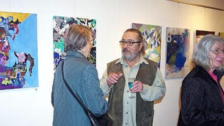 Christian Ianza im Gespräch mit Ausstellungsbesuchern. Im Hintergrund einige der 44 Exponate Foto: Heike Schülein