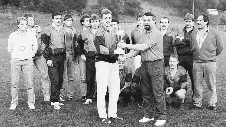 Der Spielf&uuml;hrer des SC Diebach nimmt aus den H&auml;nden von Mitorganisator Gottfried Kolb (FC Thulba) den Pokal entgegen.