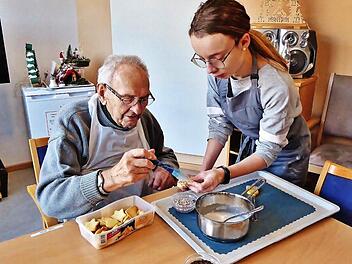 Mit ruhiger Hand bestreicht der 97-j&auml;hrige Werner Geiger die Pl&auml;tzchen mit Zuckerguss und bestreut sie mit Schokoraspeln.  Fotos: Bernd Kleinert