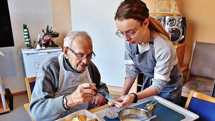 Mit ruhiger Hand bestreicht der 97-j&auml;hrige Werner Geiger die Pl&auml;tzchen mit Zuckerguss und bestreut sie mit Schokoraspeln.  Fotos: Bernd Kleinert