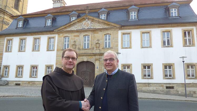 Mit Handschlag besiegelten Pfarrer Pater Ludwig Mazur und  Bürgermeister Hanngörg Zimmermann vor dem Pfarrhaus den Eigentümerwechsel.   Thomas Weichert