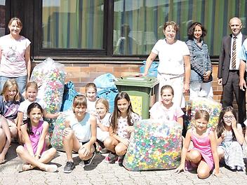 Die Marktleugaster Schüler mit ihren gesammelten Deckeln und (stehend von links) dem Initiator der Aktion und Elternbeiratsvorsitzendem Marc Hartenberger, den Elternbeiräten Kerstin Pittroff, Anja Vogel, der stellvertretenden Schulleiterin Annette Marx, 1. Bürgermeister Franz Uome, Roland Rödel vom Getränkehandel Rödel aus Marktleugast mit Enkeltochter Robin sowie Michaela und Johannes Döring. Foto: Klaus-Peter Wulf