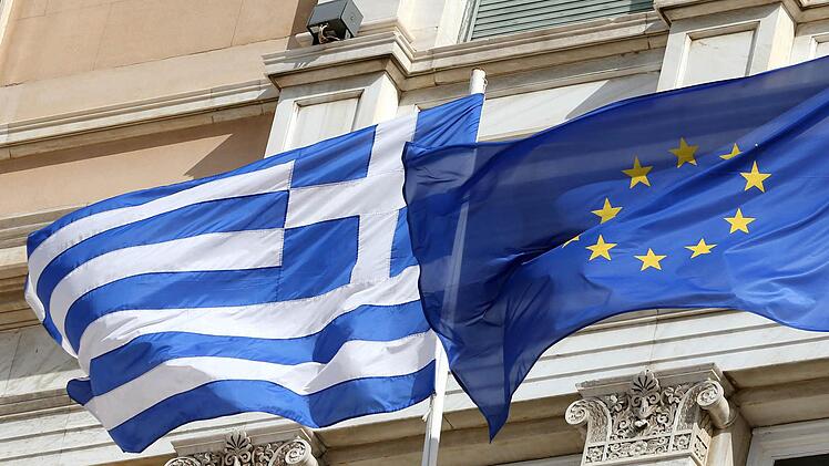 Die griechische und die europäische Flagge wehen vor dem Parlamentsgebäude in Athen. Selbst in Griechenlands schwersten Zeiten trat Deutschland für dessen Verbleib in der Eurozone ein. Die Merkel-Regierung soll von dieser Haltung abgerückt sein Foto: Wolfgang Kumm/dpa