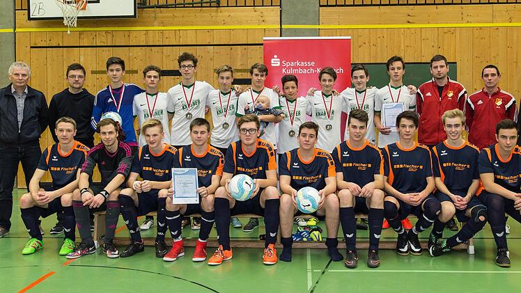 Die SG Neukenroth (weiße Trikots) holte gestern den Kronacher Hallentitel der B-Junioren. Zweiter wurde die SG Wilhelmsthal (sitzend). Mit im Bild (von links) Kreisjugendleiter Michael Deuerling sowie die Betreuer Uli Punzelt (Neukenroth), Manuel Neder und Marcel Adam (beide Wilhelmsthal) . Foto: Heinrich Weiß