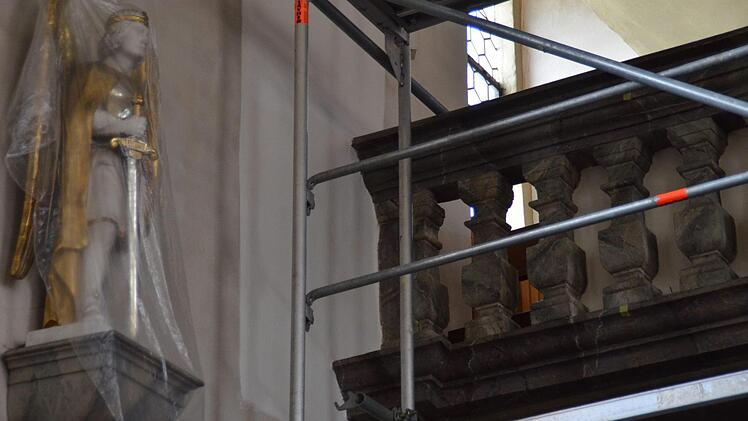 Die Figur des Heiligen Michael ist verhüllt. Der Restaurator hat an der wand zur Empore einen Testfarbstreifen angelegt. Zudem hat er an der Brüstung ein Stück der Verkleidung entfernt. Foto: Kathrin Kupka-Hahn
