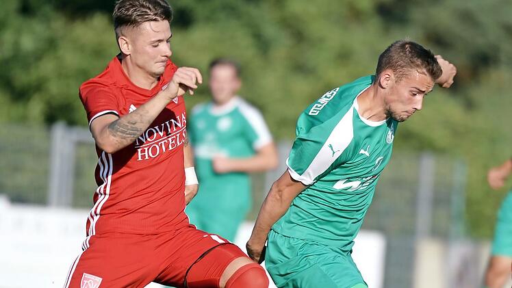 Der Neudrossenfelder Levin Pauli sp&uuml;rt den Atem seines Kornburger Gegenspielers Kevin Schwarz im Nacken.  Foto: Peter Mularczyk