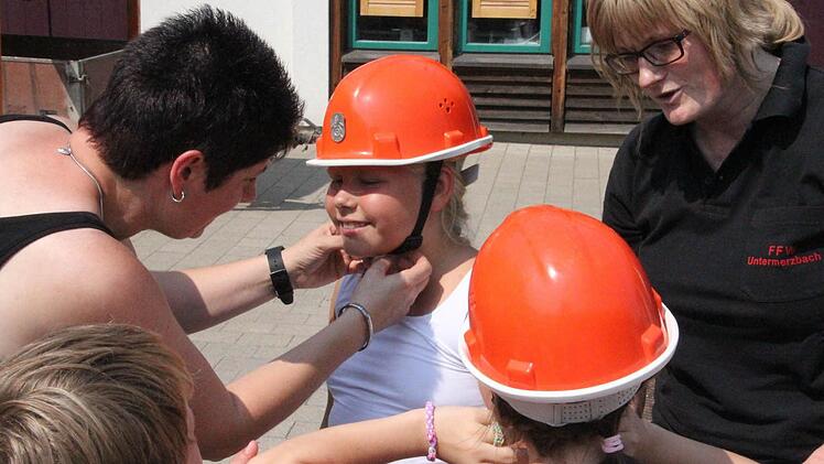 Helmanprobe vor dem Start mit den "rasenden Stühlen." Sandra Schramm und Silvia Reisenweber (von rechts) achten darauf, dass er sitzt.