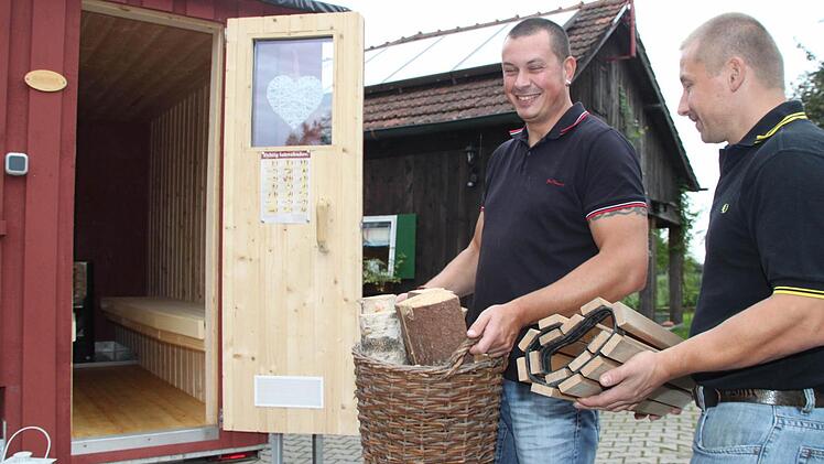 Stefan Wagner und Bernd Lattner (rechts) laden den Korb mit Holz und die Fußmatte ein. Foto: Stephan Tiroch