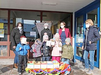 Kerstin Zufraß, Johannes Christau, Judith Lütt und Gudrun Bühner zusammen mit betreuten Kindern und den Schlitten, von dem sich die anderen Kinder etwas mit hach Hause nehmen können,