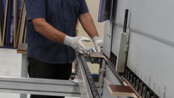 Waldemar Matysiak aus Mitgenfeld arbeitet an der Kantenanleim-Maschine. Sein Kollege Peter Schönstein aus Schondra bearbeitet ein Teilstück mit dem Hammer.