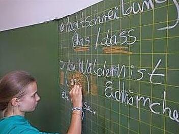 Eine Sch&uuml;lerin schreibt an der Schultafel.