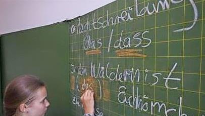 Eine Sch&uuml;lerin schreibt an der Schultafel.