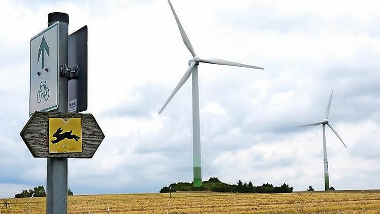 Im Zwiespalt: An die beiden Windkraftanlagen auf dem Bretzenstein hoch über Ebern und dem Itzgrund haben sich die Leute längst gewöhnt, meint Eberns Altbürgermeister Robert Herrmann in seiner Eigenschaft als Vorsitzender der Bürgerwald-Körperschaft. Foto: Berthold Köhler