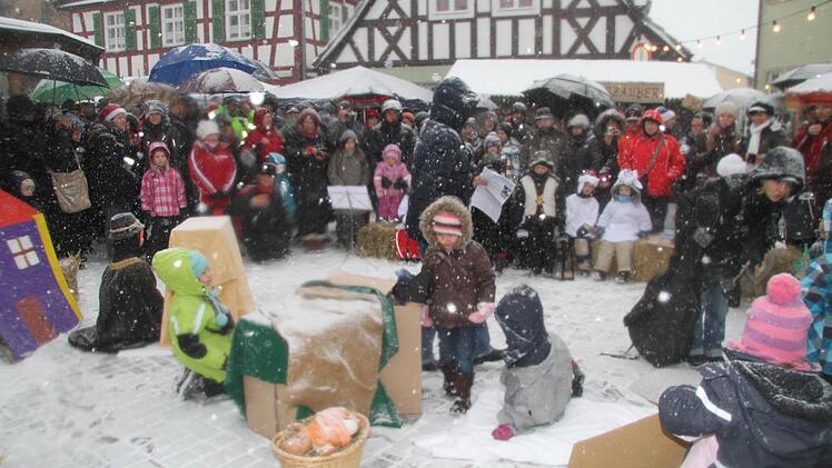Trotz dichten Schneetreibens führt der Kindergarten ein Adventsspiel auf.