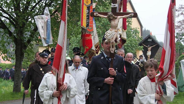 Der 23jährige Feuerwehrmann Dominik Rauh aus Steinbach trug das Kruzifix und führte den Wallfahrtszug an. Fotos: Sonja Adam