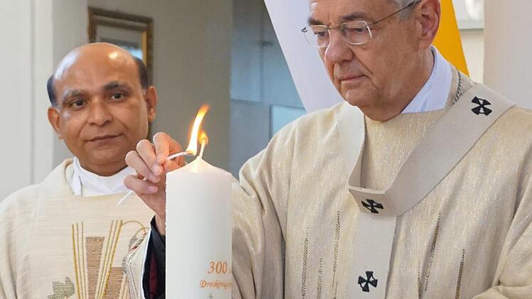 Erzbischof Schick segnet und entzündet die Jubiläumskerze unter den Augen von Pfarrer Kurian.Johannes Michel