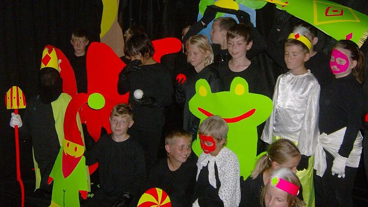 Mit Schwarzlicht und leuchtender Kleidung bringen die Gräfenberger Viertklässler ein ungewöhnliches Theaterstück auf die Bühne. Fotos: Malbrich