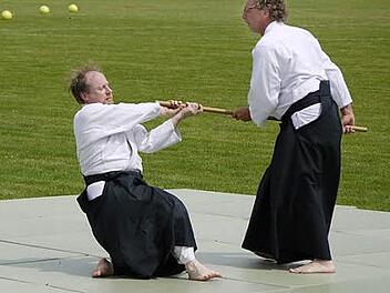 Burkard Geist (r.) demonstrierte die hohe Kampfkunst von Aikido. Hier setzt er sich gegen einen Angreifer mit dem Stock zur Wehr.  Foto: Erlwein