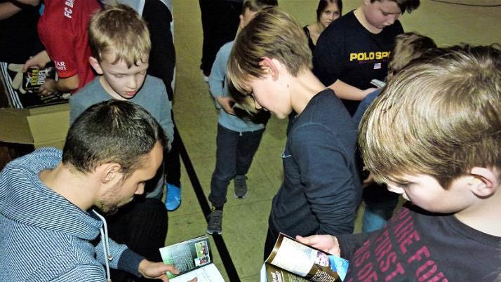 Die Jungs bekamen eine von Manuel Bühler signierte "Kicker-Bibel" als Geschenk. Foto: Reißaus
