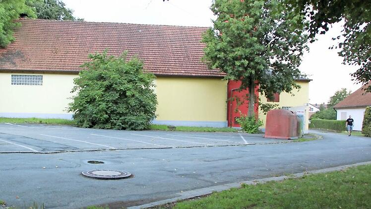 Keinen schönen Anblick bietet der Platz zwischen dem Kleukheimer TSV-Sportheim und dem alten Feuerwehrhaus (im Bild). Nun soll er neu asphaltiert und hergerichtet werden. Foto: Matthias Einwag