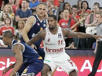 Lorenzo Williams (l.) ist nach den Worten von Brose-Coach Andrea Trinichieri "in der Offensive eine richtige Nervensäge". Hier verteidigt Brad Wanamaker gegen den Bremerhavener Aufbauspieler. Im Hintergrund ist Sven Schultze, der Bamberger im Eisbären-Trikot, zu sehen. Foto: sportpress
