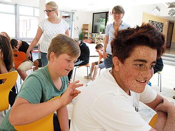 Da heißt es, sich konzentrieren. Was malt der Mitschüler auf den Rücken? Das Bild muss an den Vordermann weitergegeben werden. Brigitte Schnabel und Nicole Kollarsch sind gespannt, was dabei herauskommt.  Foto: Christiane Lehmann