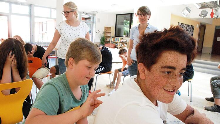 Da heißt es, sich konzentrieren. Was malt der Mitschüler auf den Rücken? Das Bild muss an den Vordermann weitergegeben werden. Brigitte Schnabel und Nicole Kollarsch sind gespannt, was dabei herauskommt.  Foto: Christiane Lehmann