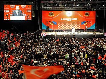 Fahnen der Türkei werden geschwenkt während der türkische Ministerpräsident Recep Tayip Erdogan am 24.05.2014 in Köln (Nordrhein-Westfalen) in der Lanxess-Arena spricht. Erdogan trat auf einer Veranstaltung der UETD in Köln auf. Foto: Henning Kaiser/dpa