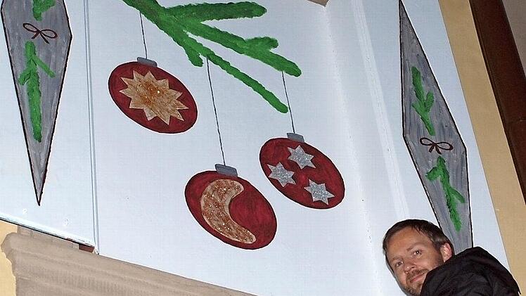 Mario Pelikan öffnete das 4. Adventsfenster, hinter dem ein Tannenzweig mit drei Christbaumkugeln zum Vorschein kam. Fotos: Alfred Thieret