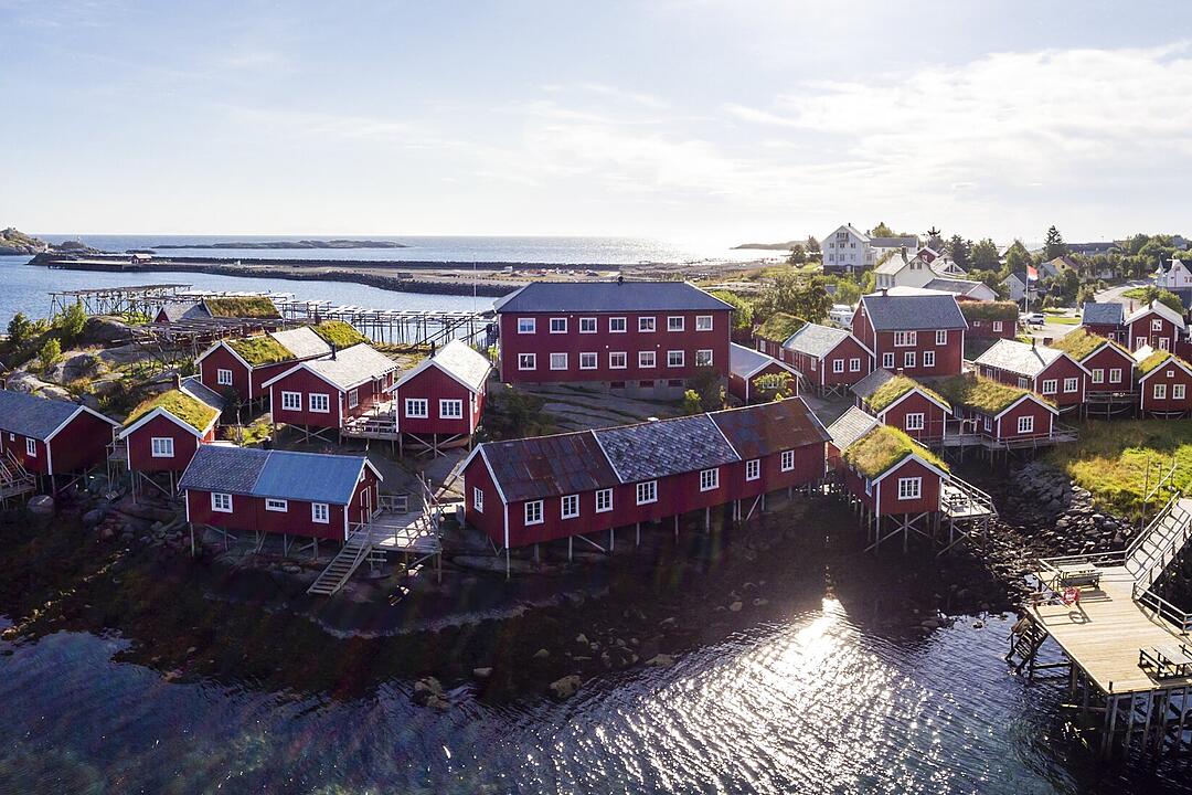 Reine Rorbuer - Foto Classic Norway Rorbuer heißen die Fischerhütten in Reine. Die roten, historischen Stelzenhäuser liegen direkt in der Ortsmitte und bieten einen tollen Blick über den Fjord und die majestätischen Berge.  Reine ist mit Sicherheit einer der schönsten und fotogensten Orte auf den Lofoten.