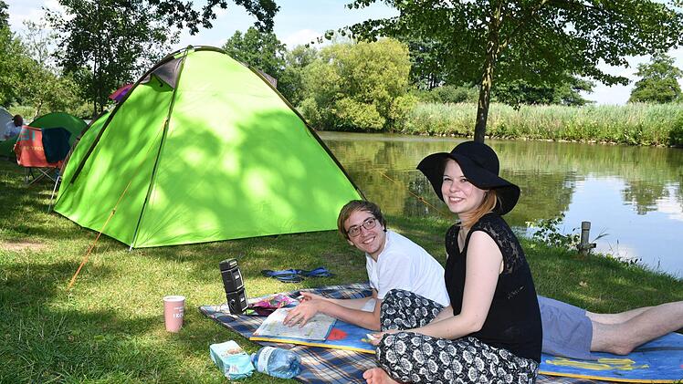 Decke, Kreuzworträtselheft und Handy-Lautsprecher: Timo Schlesinger und Lara Kröger haben ihr Camping-Wohnzimmer am Regnitzufer aufgebaut. Foto: Ronald Rinklef