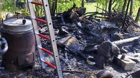 Der Auslöser des Brandes (links) inmitten verkohlter Gegenstände. Funken des kleinen Ofens entzündeten die Scheunenwand. Fotos: Marco Meißner