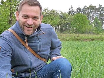 Alexander Ulmer vom LBV zeigt rote Adonisröschen am Rand eines Ackers am Lauterberg. Daneben die Blüten in Großaufnahme, bei Sonnenschein geöffnet. Fotos: Rainer Lutz/Alexander Ulmer