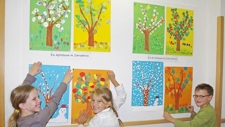 Antonia, Janina und Moses (von links) haben viel Spaß beim Aufhängen der Bilder. Foto: Heike Schülein