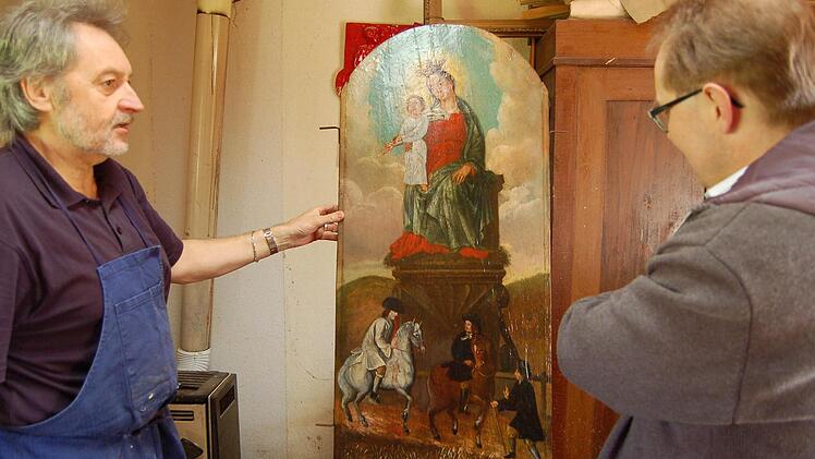 Restaurator Reinhold Müller und Pfarrer Thomas Eschenbacher begutachten das renovierte Bild. Foto: Barbara Oschmann