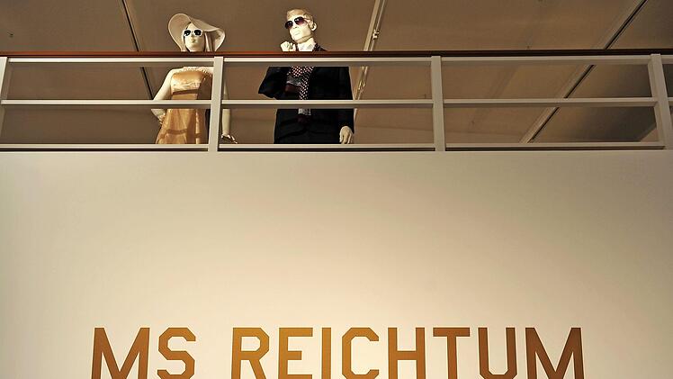 Im Eingang der Ausstellung "MS Reichtum" im Deutschen Hygiene-Museum in Dresden stehen zwei Schaufensterpuppen an einer Reling einer Schiffsatrappe.  Foto: B. Jutrczenka, dpa