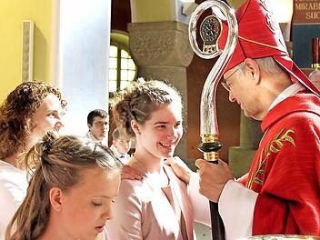 Tina Noppenberger empfängt das Sakrament der Firmung - dahinter ihre Patin Annika Fix. Foto: Johanna Blum