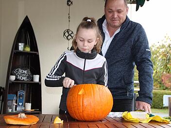 Da schnitzt die Könnerin: Lea Belz verpasst dem Kürbis den letzten Schliff. Papa Oliver hat schon vorgearbeitet. Foto: Ulrike Müller