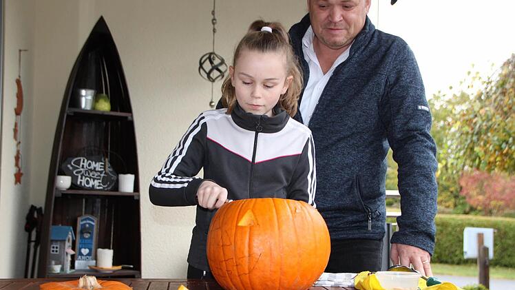 Da schnitzt die Könnerin: Lea Belz verpasst dem Kürbis den letzten Schliff. Papa Oliver hat schon vorgearbeitet. Foto: Ulrike Müller