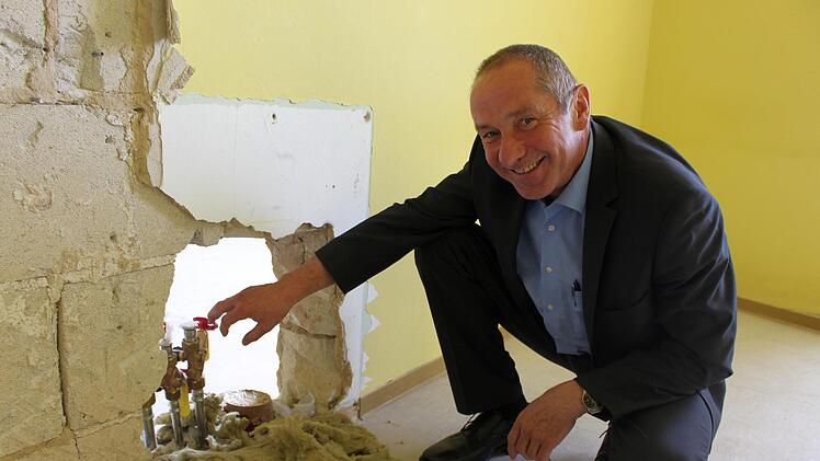 Klaus Hofmann zeigt auf Wasserrohre, die von der Klosterschänke in den 1. Stock reichen und bereits im Rahmen der Schänkensanierung errichtet wurden.  Foto:  Julia Raab