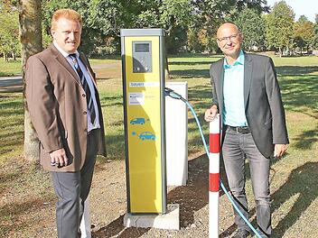 Eine Stromtankstelle eröffneten Bürgermeister Matthias Klement (links) und Günter Jira vom Kommunalmanagement des Bayernwerks (rechts) auf dem Lauertal-Parkplatz in Maßbach.  Foto: Dieter Britz