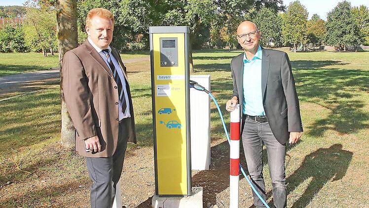 Eine Stromtankstelle eröffneten Bürgermeister Matthias Klement (links) und Günter Jira vom Kommunalmanagement des Bayernwerks (rechts) auf dem Lauertal-Parkplatz in Maßbach.  Foto: Dieter Britz