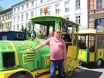 Fahrer Gunter Repp posiert während einer kurzen Pause vor der Lok. Die Geckobahn hält am Rondell vor dem Kurgarten. Foto: Charlotte Wittnebel-Schmitz