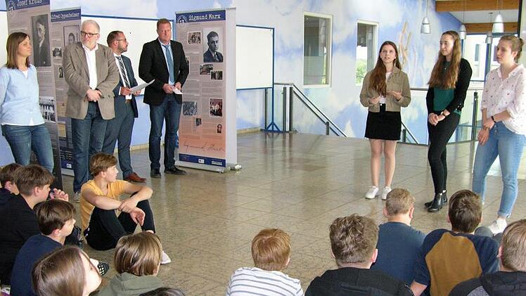 In Anwesenheit von Rektor Michael Lege, Landrat Sebastian Straubel und Bürgermeister Michael Keilich (links) erläutern die Meranerinnen Sophie Rauh, Laura Kolenda und Victoria Thiel (rechts) Details ihrer umfangreichen Recherchen. Foto: Klaus Oelzner