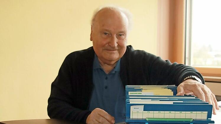 Gerhard Arneth mit dem Repertorium (dem "Findbuch") und mit einer Box voller sortierter und beschrifteter Fotos aus Ebensfeld und den Gemeindeteilen